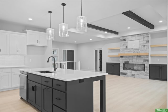 kitchen featuring dishwasher, white cabinetry, sink, and decorative light fixtures