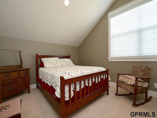 bedroom with light colored carpet and lofted ceiling