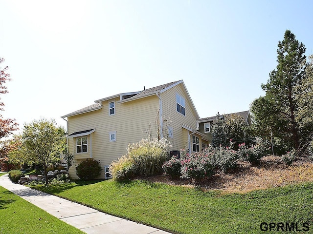 view of side of home with a yard