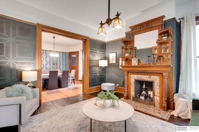 living room with a fireplace, hardwood / wood-style floors, and a chandelier