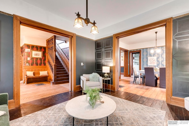 living room featuring wood-type flooring and an inviting chandelier