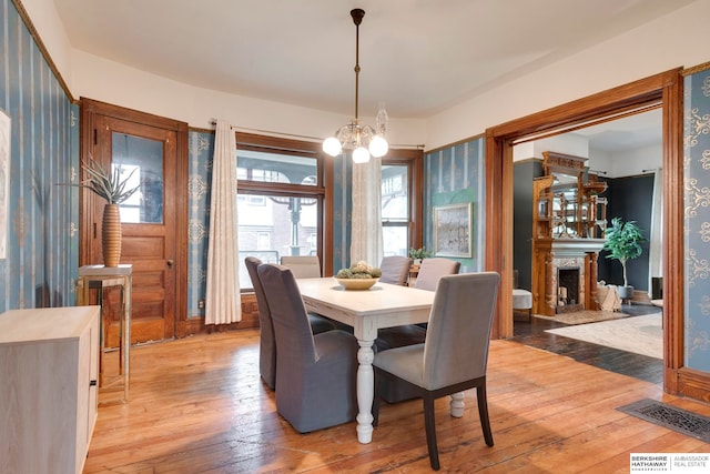 dining space with a notable chandelier and light hardwood / wood-style floors