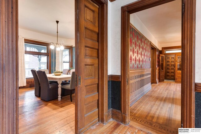 hallway featuring a notable chandelier and light hardwood / wood-style floors