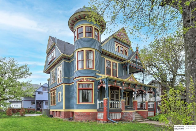 view of front of property featuring covered porch and a front lawn