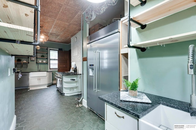 kitchen featuring sink, white cabinets, and premium appliances