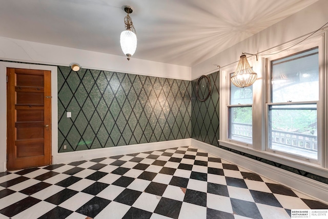 unfurnished room featuring an inviting chandelier