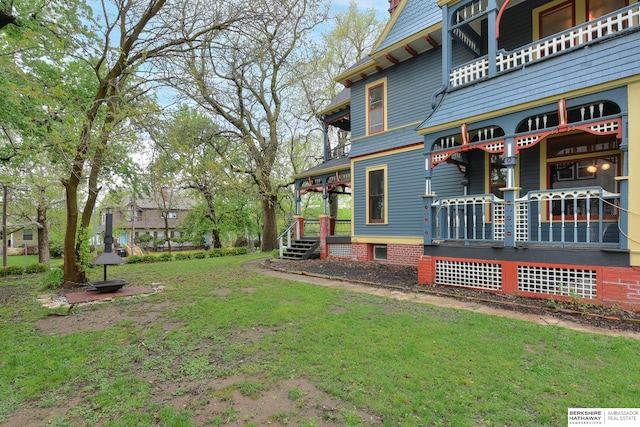 view of yard featuring covered porch and a balcony