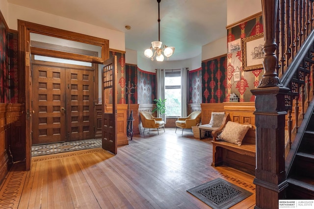 foyer with hardwood / wood-style flooring and an inviting chandelier