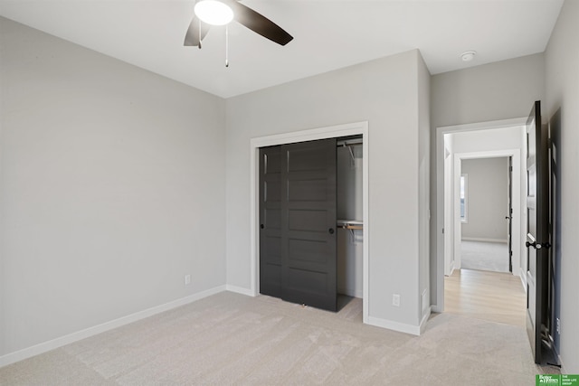 unfurnished bedroom with light carpet, a closet, and ceiling fan