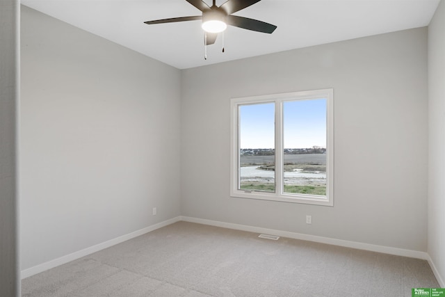 spare room with ceiling fan and light colored carpet