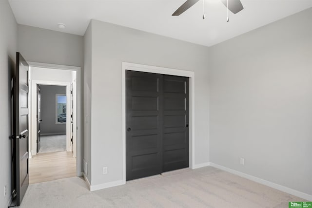 unfurnished bedroom with ceiling fan, a closet, and light colored carpet