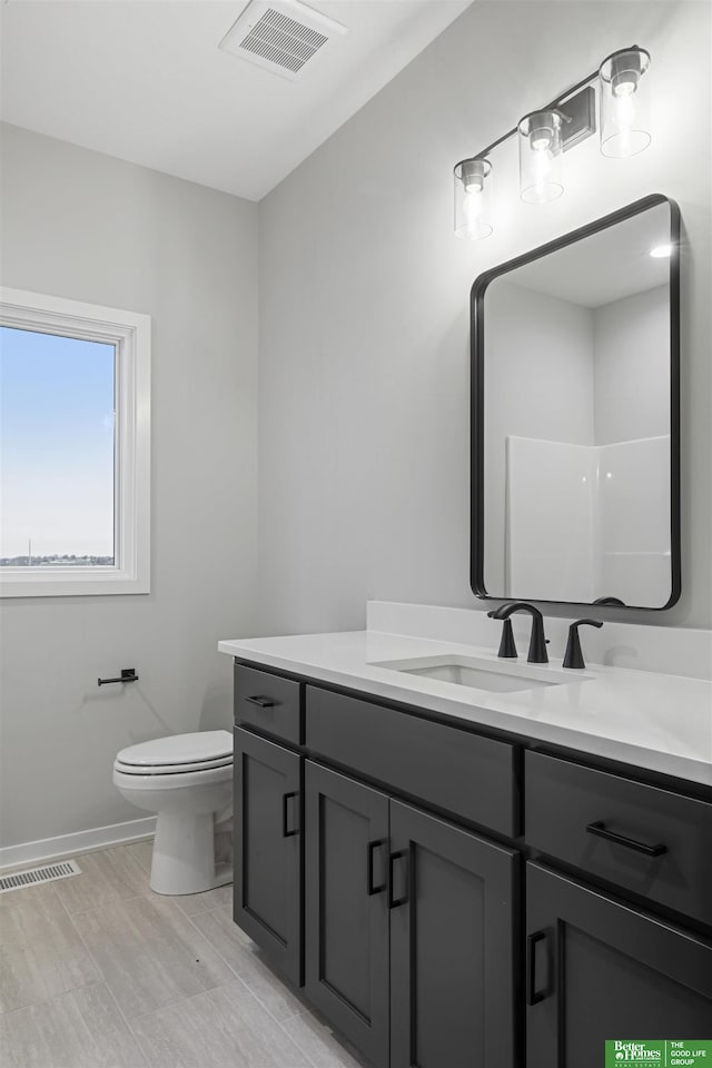 bathroom featuring wood-type flooring, vanity, and toilet