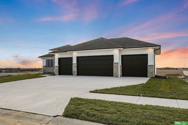 prairie-style home with a garage and a lawn