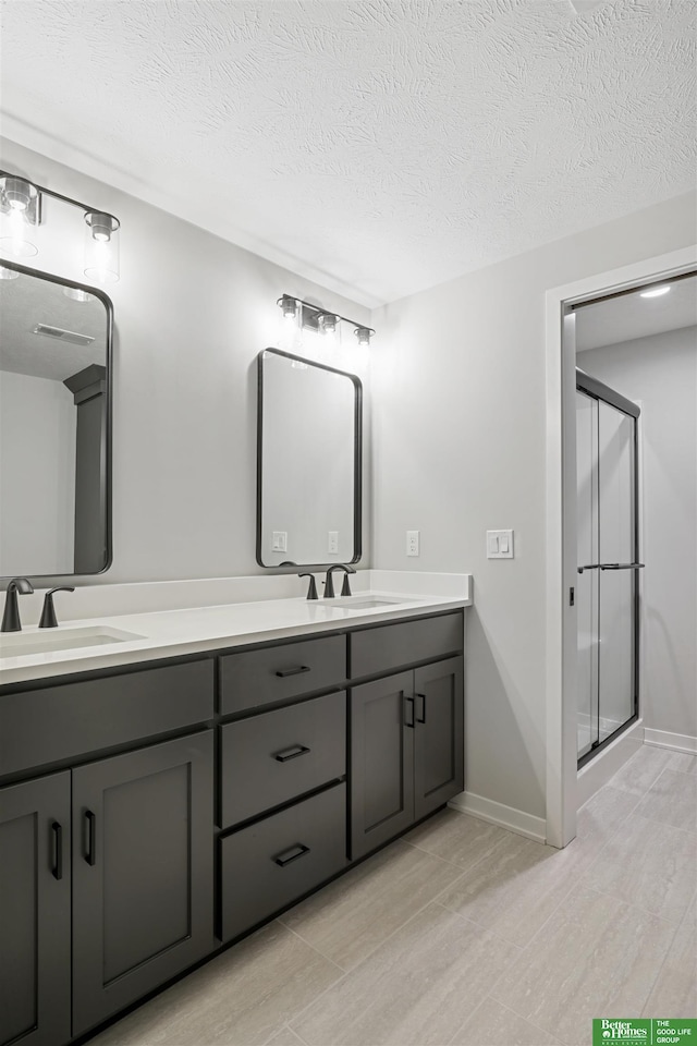 bathroom featuring hardwood / wood-style floors, vanity, a textured ceiling, and a shower with door