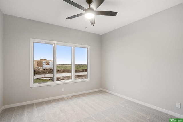 carpeted spare room featuring ceiling fan