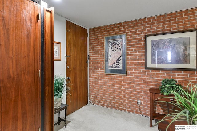 interior space featuring wood walls, light colored carpet, and brick wall