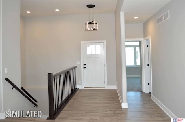 foyer entrance featuring light wood-type flooring and a notable chandelier