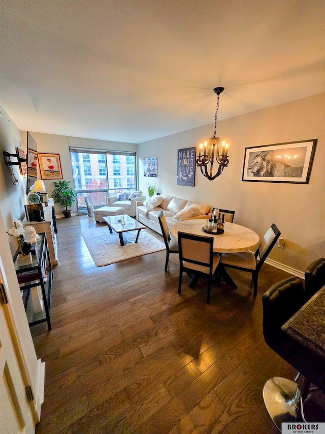 dining room with dark hardwood / wood-style floors and an inviting chandelier