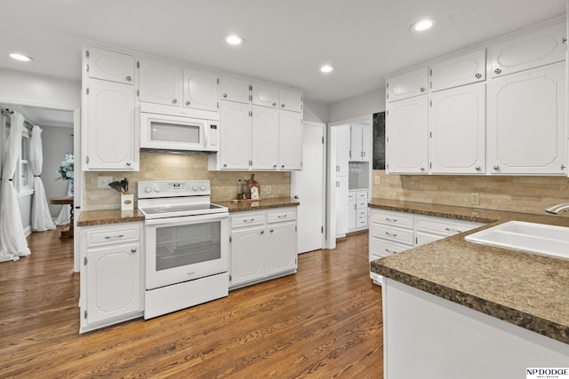 kitchen featuring white appliances, backsplash, sink, dark hardwood / wood-style flooring, and white cabinetry