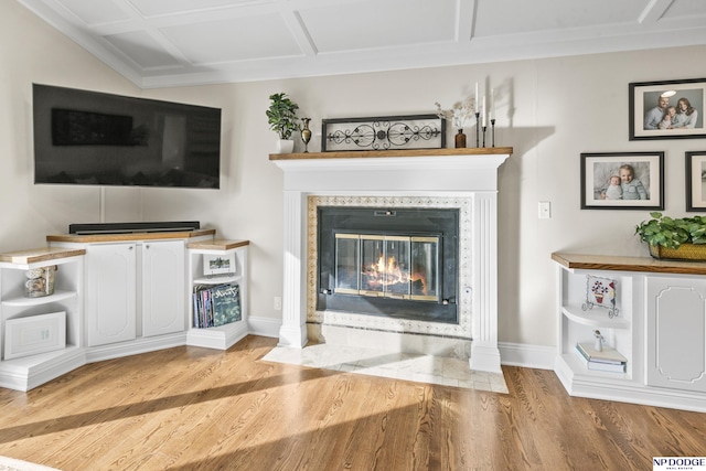 unfurnished living room with a tiled fireplace, light hardwood / wood-style flooring, and coffered ceiling