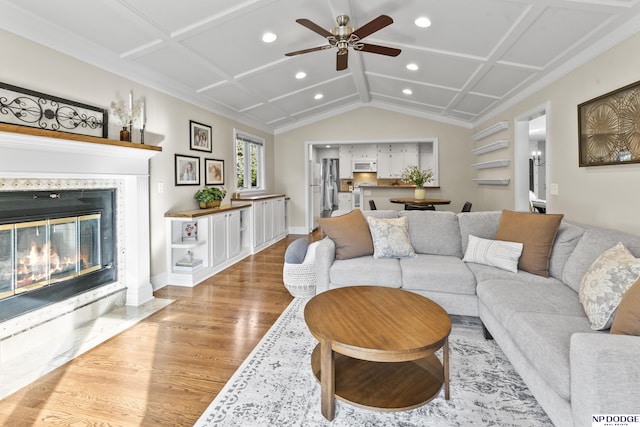 living room featuring ceiling fan, light hardwood / wood-style floors, and coffered ceiling