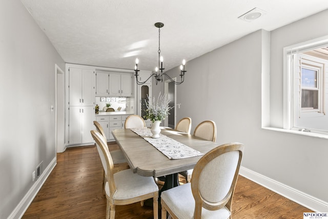 dining room featuring dark hardwood / wood-style flooring and an inviting chandelier