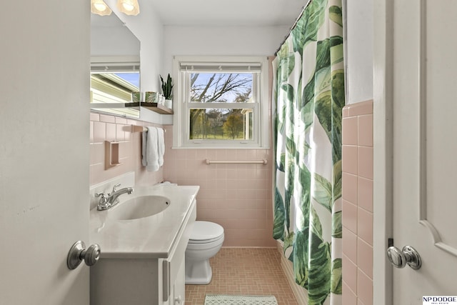 bathroom featuring tile patterned flooring, toilet, vanity, tile walls, and a shower with shower curtain