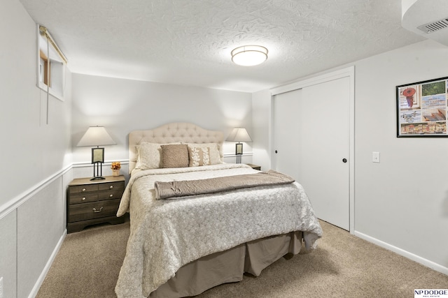 bedroom featuring light carpet, a closet, and a textured ceiling