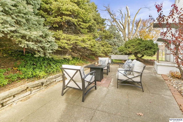 view of patio with an outdoor living space with a fire pit