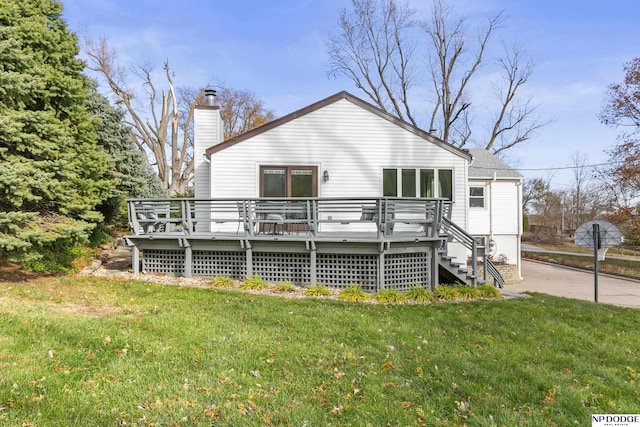 rear view of house with a deck and a lawn