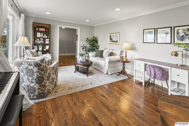 living room with dark wood-type flooring, a healthy amount of sunlight, and ornamental molding