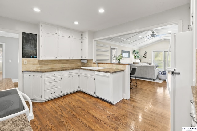 kitchen with white appliances, vaulted ceiling with beams, white cabinetry, and backsplash