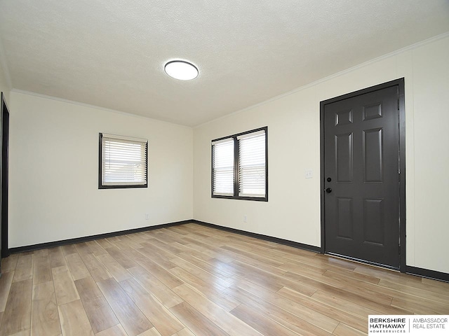 entryway with plenty of natural light, a textured ceiling, and light hardwood / wood-style flooring