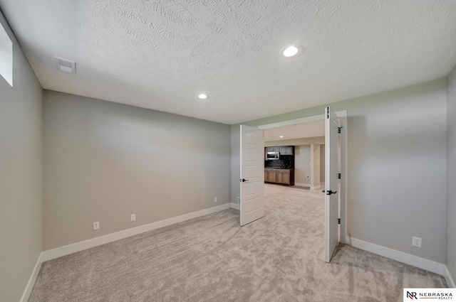 carpeted empty room with a textured ceiling