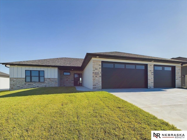 prairie-style home featuring a garage and a front lawn