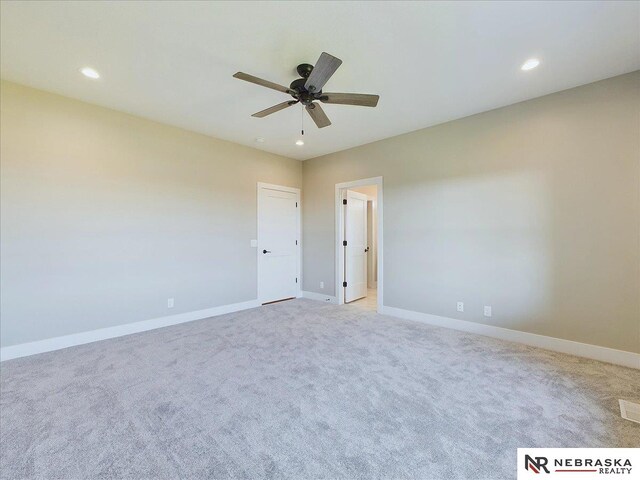 empty room with ceiling fan and light colored carpet