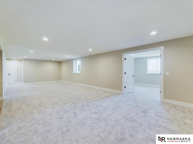 basement featuring light colored carpet and a wealth of natural light