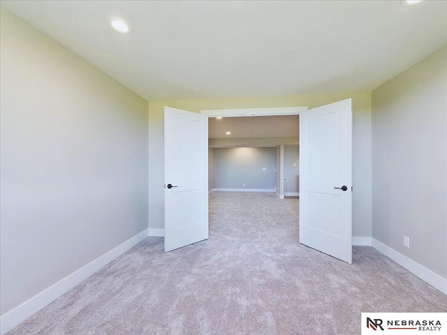 unfurnished room featuring light colored carpet