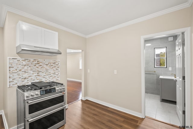 kitchen featuring range with two ovens, crown molding, hardwood / wood-style flooring, range hood, and white cabinetry