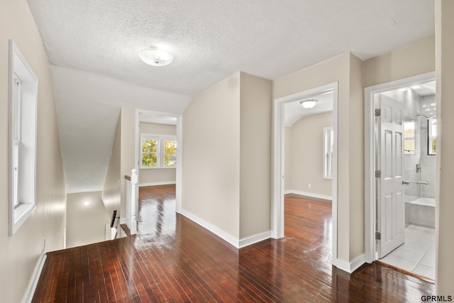 hallway with light hardwood / wood-style floors and a textured ceiling