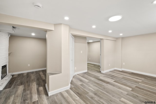 basement featuring wood-type flooring and a fireplace