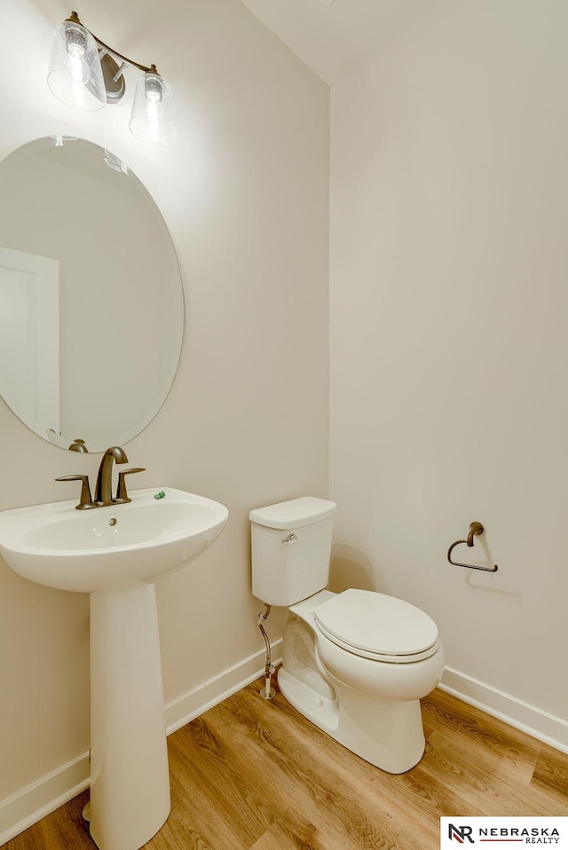 bathroom with sink, toilet, and hardwood / wood-style flooring