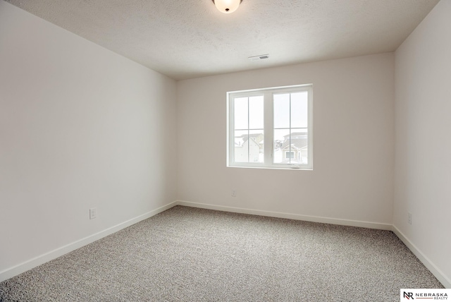 unfurnished room featuring carpet flooring and a textured ceiling