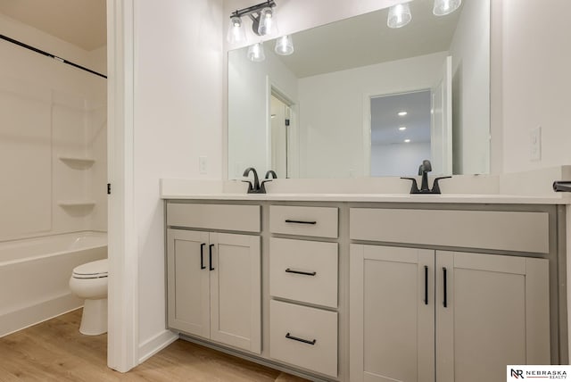 full bathroom with shower / bathing tub combination, vanity, toilet, and hardwood / wood-style floors