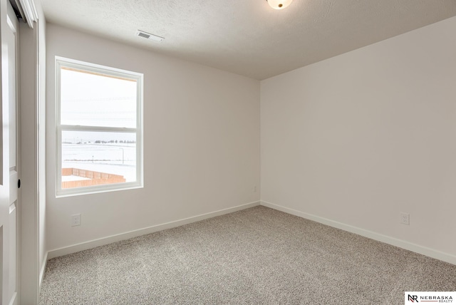 unfurnished room with a textured ceiling and carpet flooring