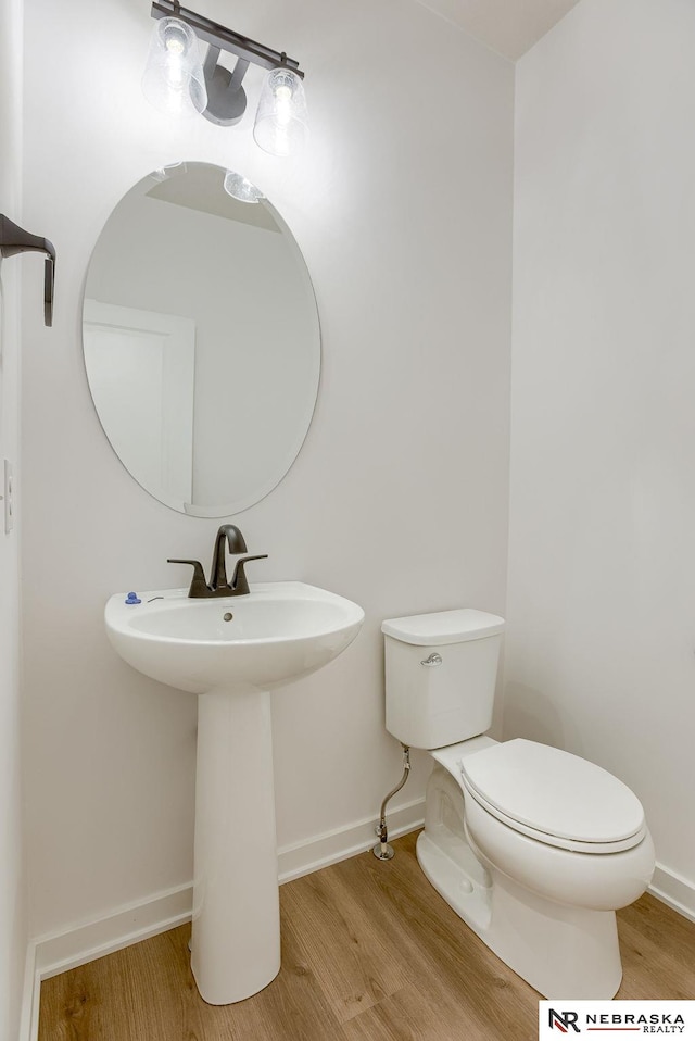 bathroom with hardwood / wood-style flooring and toilet