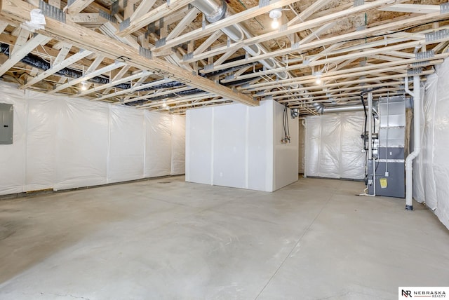 basement featuring electric panel and heating unit