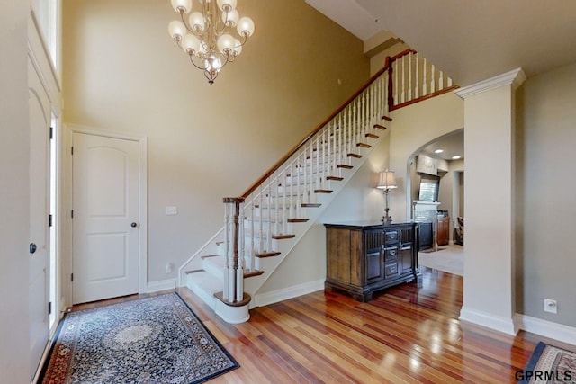 foyer with hardwood / wood-style flooring, a notable chandelier, and a high ceiling