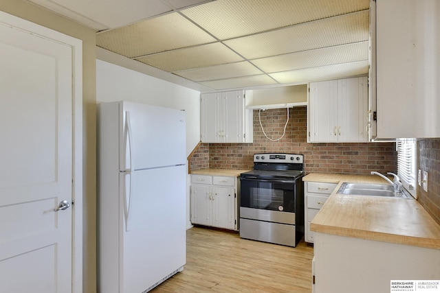 kitchen featuring sink, electric stove, white refrigerator, light hardwood / wood-style flooring, and white cabinets