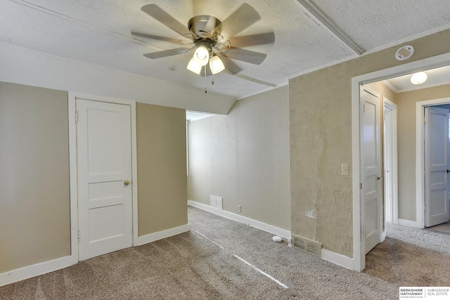 empty room with carpet, ceiling fan, and a textured ceiling